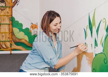 Caucasian Woman Artist Hand Painting Murals On Walls Indoor At Apartment Or Studio School With Acryl