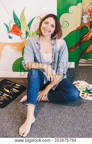 Caucasian Woman Artist Relaxing After Hand Painting Murals On Walls Indoor At Apartment Or Studio Sc