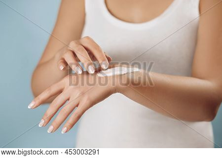 Closeup Of Female Hands Applying Hand Cream, Lotion. Hand Skin Care. Beautiful Woman Hands With Fren