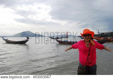 Traveler Thai Women Playing Water In Sea Ocean On Eastern Shore Of The Gulf Of Thailand While Rainin