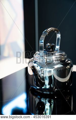 Stainless Water Crow Or Vintage Kettle Tea Pot On Electronic Stove In Modern Dark Blue Background.