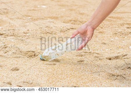 Woman Cleans Up By Picking Up Plastic Bottles At Beach. Concept Of Protecting The Environment, Savin