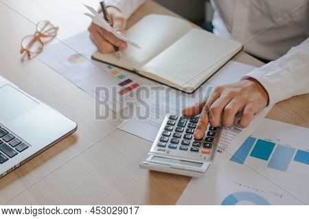 Close Up Hand Of Stress Young Asian Businessman,male Is Pressing A Calculator To Calculate Tax Incom