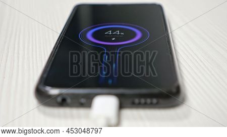 The Phone Lie On The Table Charging Fast Connection To Your Phone By Wire, Upper View