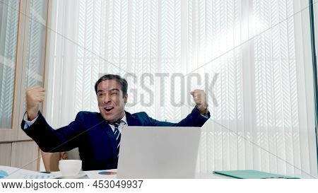 Happy Business Man Excited Surprised Work At White Office Desk With Pc Laptop Throwing Up Paper Acco