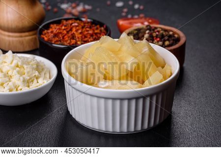 Canned Pineapple Chunks In A White Bowl On A Dark Concrete Background