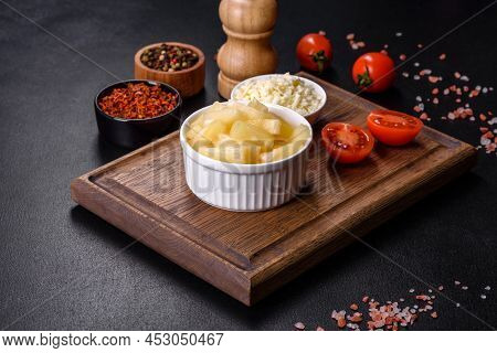 Canned Pineapple Chunks In A White Bowl On A Dark Concrete Background