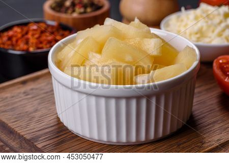 Canned Pineapple Chunks In A White Bowl On A Dark Concrete Background