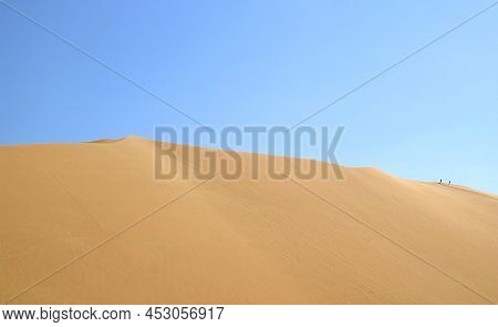 Massive Sand Dune Of Huacachina Desert With People Walking On The Top, Ica Region Of Peru, South Ame