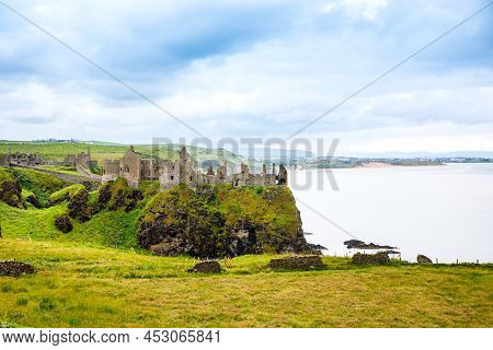Ruins Of Dunluce Castle, Antrim, Northern Ireland During Sunny Day With Semi Cloudy Sky. Irish Ancie