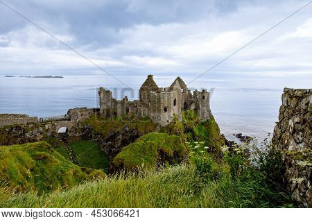 Ruins Of Dunluce Castle, Antrim, Northern Ireland During Sunny Day With Semi Cloudy Sky. Irish Ancie