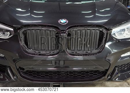 The Bmw Car, Covered With A Protective Shiny Black Paint Film, Is In A Repair Shop. Ppf Polyurethane