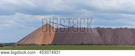 Giant Spreader Or Absetzer Machinery. A Large Dumper On A Landfill With Potash Ore. Extracting And M