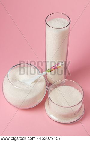 Sugar On A Pink Background. Sugar In Different Glass Vessels. Sugar Reserves