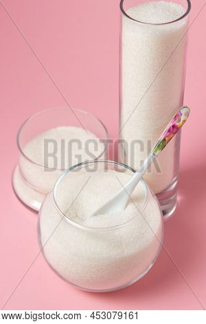 Sugar On A Pink Background. Sugar In Different Glass Vessels. Sugar Reserves