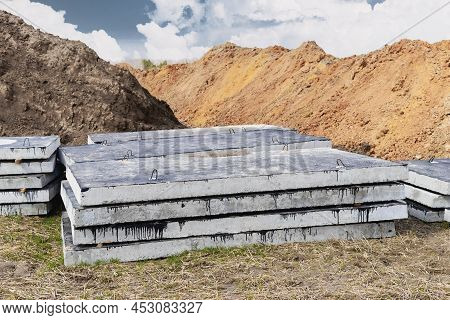 Reinforced Concrete Slabs At A Construction Site Against A Blue Cloudy Sky And Earth. Folded Plates 