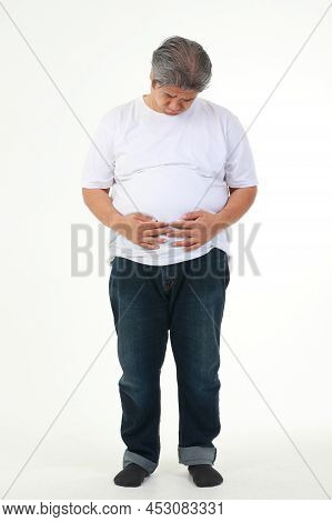 A Fat Asian Man In A White T-shirt Stood Holding His Belly. He Felt Uncomfortable, Abdominal Distens
