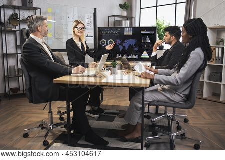 Pretty Concentrated Blond Female And Serious Indian Businessman Manager At A Meeting Together With T