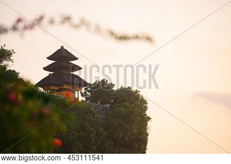 Balinese Temple On The Cliff Against The Warm Sky