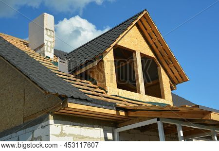 Roofing Construction On The Stage Of Metal Tiles Installation On A Gable Roof With A Dormer Using Fl