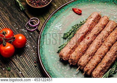 Raw Lula Kebab On Skewers With Spices On A Cutting Board Light Background. Lula Kebab, Traditional C