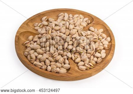 Roasted Salted Pistachio Nuts With Partly Open Shells On A Wooden Compartmental Dish On A White Back