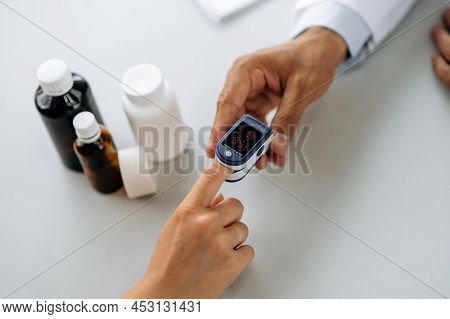 Apparatus For Measuring Oxygen Saturation And Pulse. The Doctor Measures The Patients Oxygen Saturat