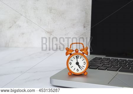 Alarm Clock Isolated On Laptop Or Notebook. The Clock Set At 5 O'clock. Business And Deadline Concep