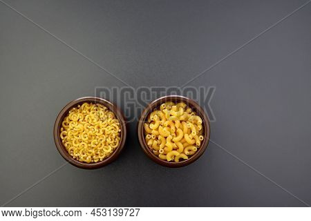 Small And Large Elbow Paste In Round Bowls On A Gray Background.