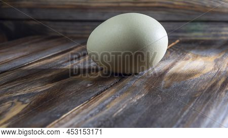Araucana Egg On Wooden Background. Light Blue Egg From Araucana Chicken. Easter Festival Concepts. E