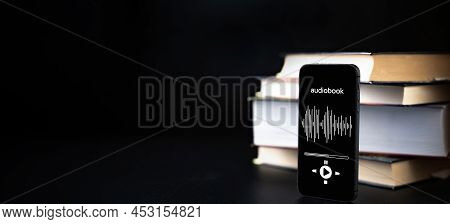 Audiobook Education. Smartphone Screen With Audiobook Application On Paper Books Black Background. E