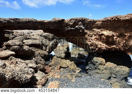Scenic Natural Arched Rock Bridge On The Coastline Of Aruba.