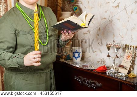 A Jewish Woman Without A Face With Awdala Candles And A Siddur In Her Hands.