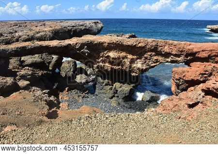 Twin Arched Natural Lava Rock Bridges Along The Coast Of Aruba.