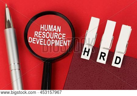 Business Concept. On The Red Surface Lies A Pen, A Notebook With Clothespins - Hrd, And A Magnifying