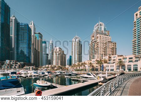 Yachts Are Moored At City Pier, Jetty In Dubai Marina. Cityscape Skyline. View Of Glass Skyscrapers 