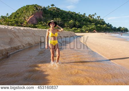 Fit Women In A Yellow Bikini At The Beach Known As Pitinga, In Arraial D\' Ajuda, Bahia, Brazil