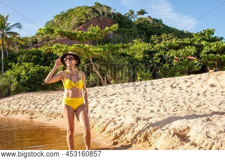 Fit Women In A Yellow Bikini At The Beach Known As Pitinga, In Arraial D\' Ajuda, Bahia, Brazil