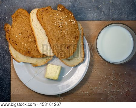 Sliced ​​loaf Bread For Breakfast With Butter. Food On The Table. Flour Products. Pieces Of Bun In H