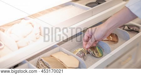 Female Hand Choosing The Glasses From The Tray That Decorated In The Built-in Wardrope In The Bedroo