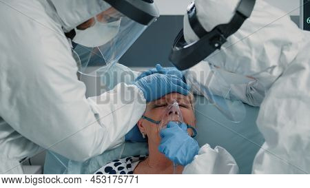 Hyperventilating Patient Asking For Medical Assistance From Paramedics In Hazmat Suits. Doctor And N