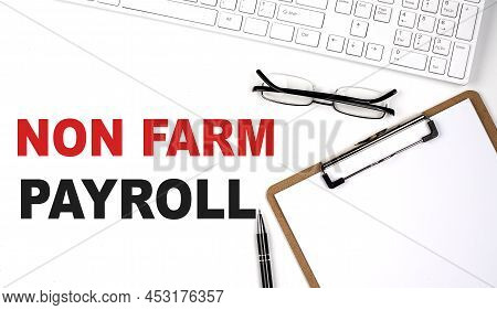 Non Farm Payroll Text Written On A White Background With Keyboard, Paper Sheet And Pen
