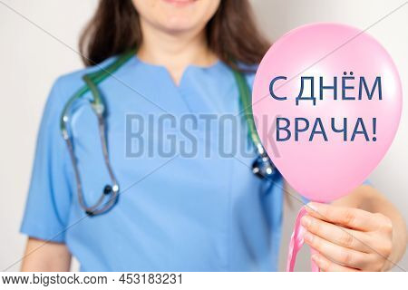 A Doctor In A Blue Uniform Holds A Blue Balloon With The Text On The Russian, Translated From Russia