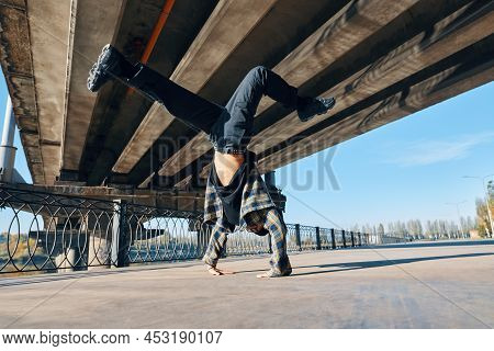 Young Man Break Dancer Dancing On Urban Background Performing Acrobatic Stunts