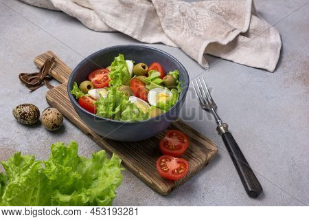 Healthy Salad With Fresh Lettuce, Cherry Tomatoes, Quail Egg And Olives In Bowl
