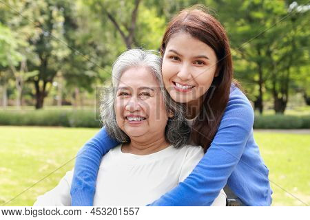 Elderly Mother And Daughter Smiling Happily In The Park In The Morning. Family Concept. Health Care 