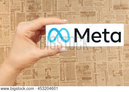 Kiev, Ukraine - January 20, 2022: Hand Holds Meta Logo, On Old Newspaper Background. Social Media Gi