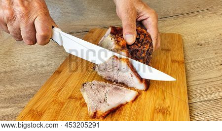 Male Rakas Cut Pork Ham Baked With A Ceramic Knife On A Touch Board