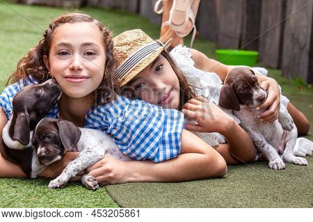 Beautiful Young Girls Having Fun With Their Small French Braque Puppies