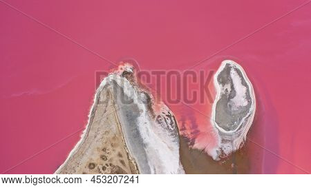 Flying Over A Pink Salt Lake. Salt Production Facilities Saline Evaporation Pond Fields In The Salty